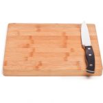 Isolated image of wooden cutting board and knife lying on a white background