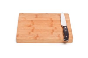 Isolated image of wooden cutting board and knife lying on a white background